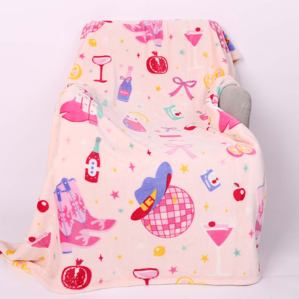 Disco cowgirl theme printed blanket laid out on a chair.