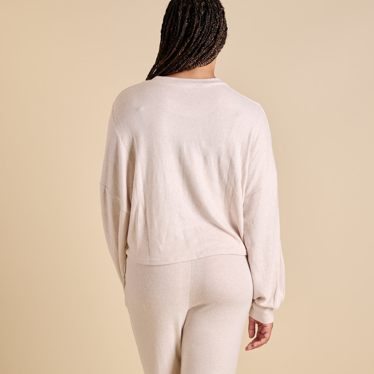 Woman wearing an oatmeal hacci lounge set.