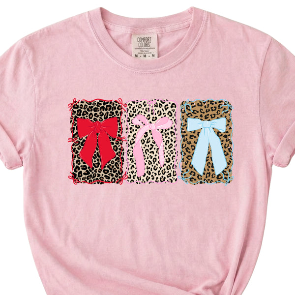 Pink t-shirt with leopard print designs and colorful bows on a white background