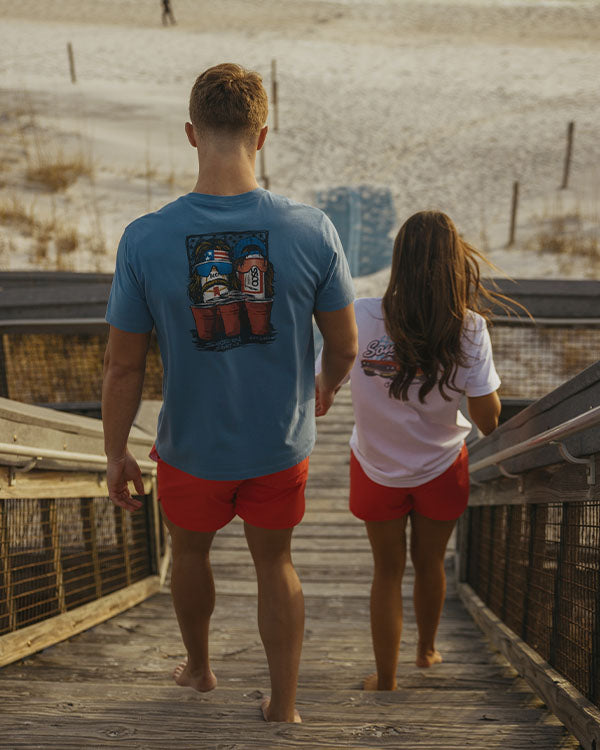 a guy and girl walking down steps to the beach