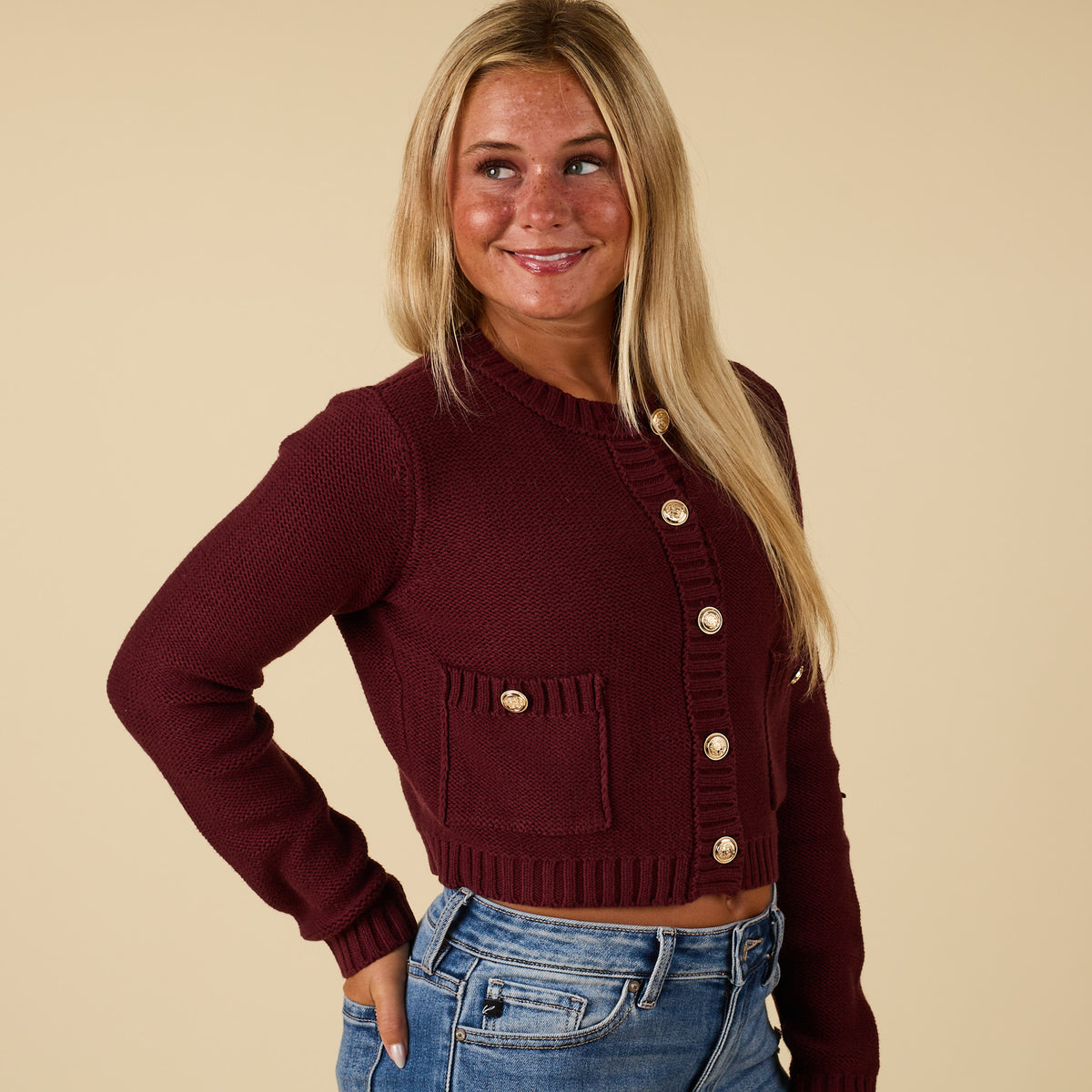 Side view of redwood cropped cardigan sweater with gold-tone button closure and patch pocket.