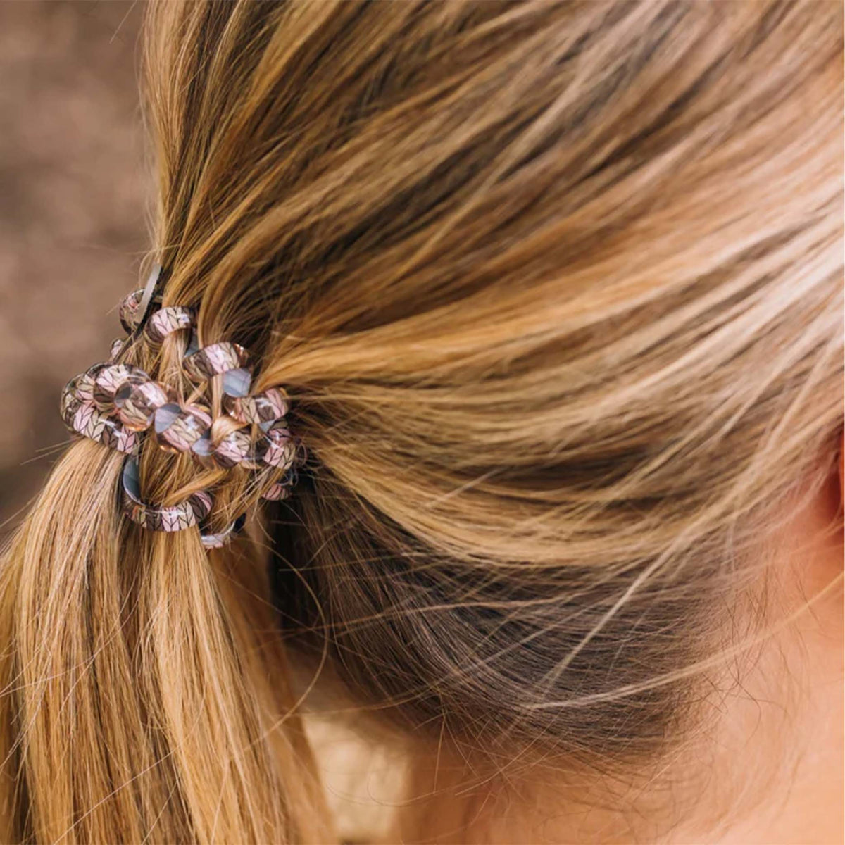 Teleties Large Hair Tie in Sage It Ain’t So securing a ponytail with layered neutral and pink tones.