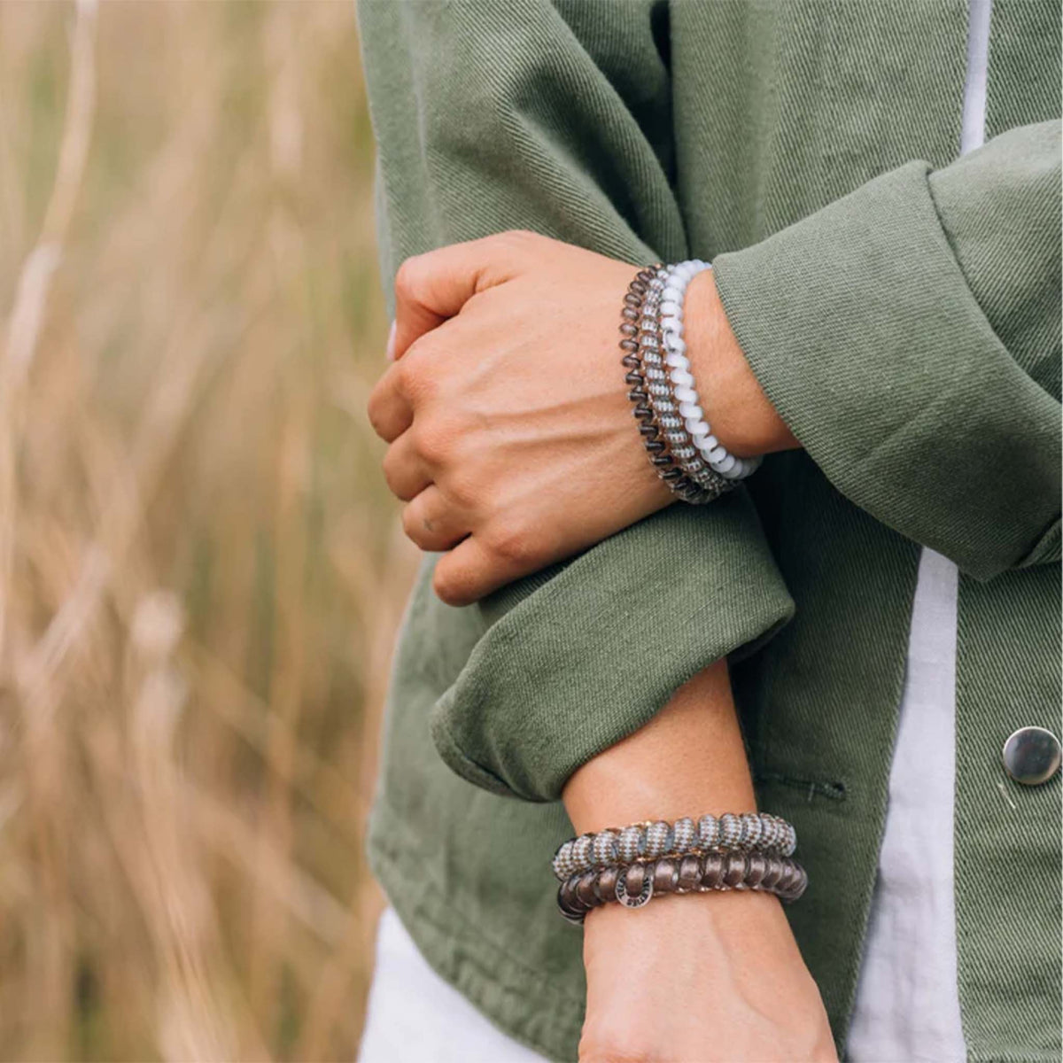 Teleties Large Hair Tie in Truly Taupe shown on wrist as stacked bracelets with casual outfit.