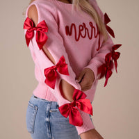 Woman posing in a bow sleeve sweater.