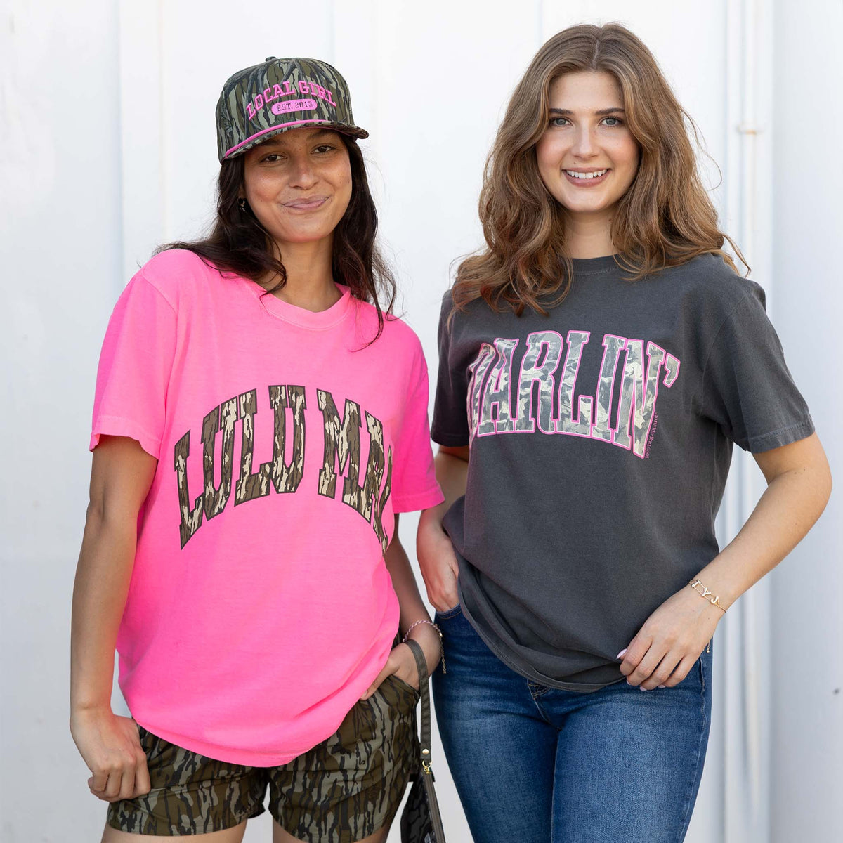 Two women wearing t-shirts with text and graphics against a white background