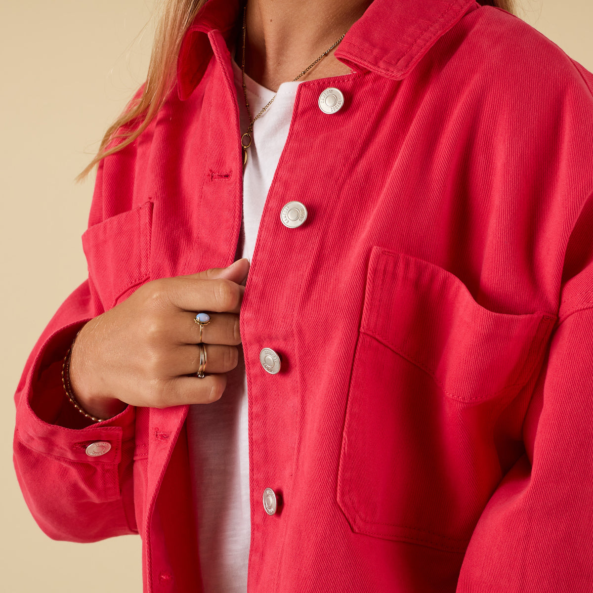 Red jacket with silver buttons on a beige background