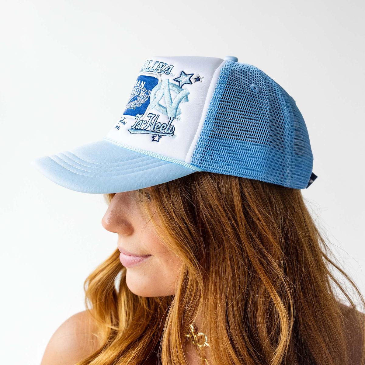 Person wearing a blue and white cap with branding on a plain background