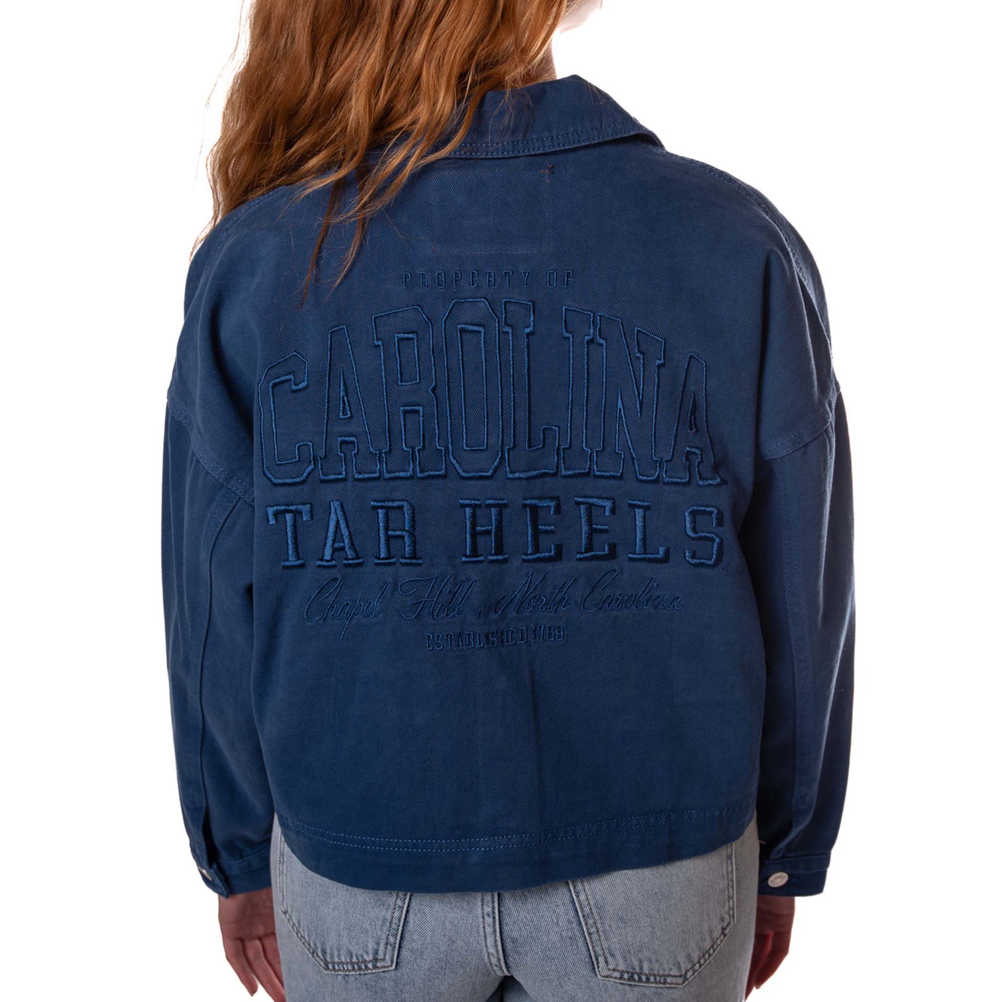 Back view of navy canvas twill jacket with large tonal embroidered “Carolina Tar Heels, Chapel Hill, North Carolina” lettering.