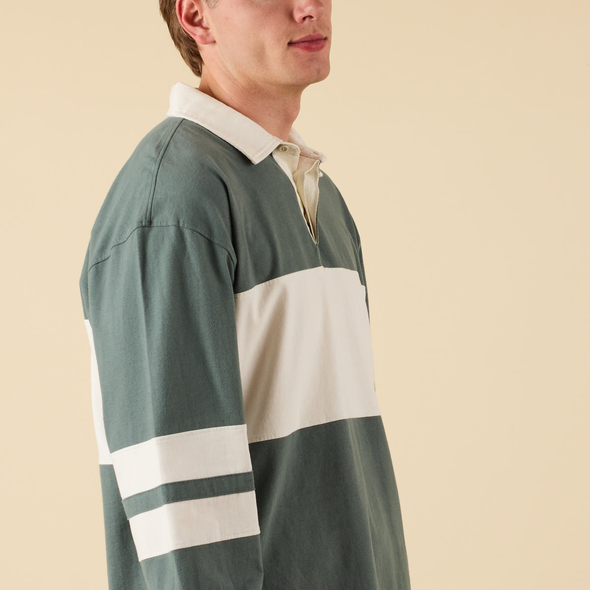 Person wearing a green and white striped shirt on a beige background