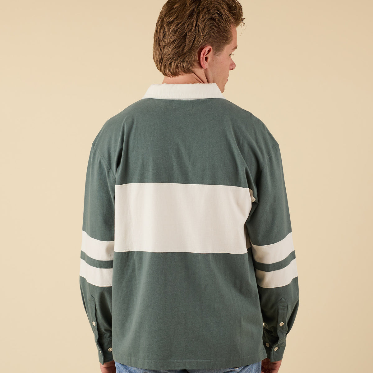 Man wearing a green and white striped shirt on a beige background