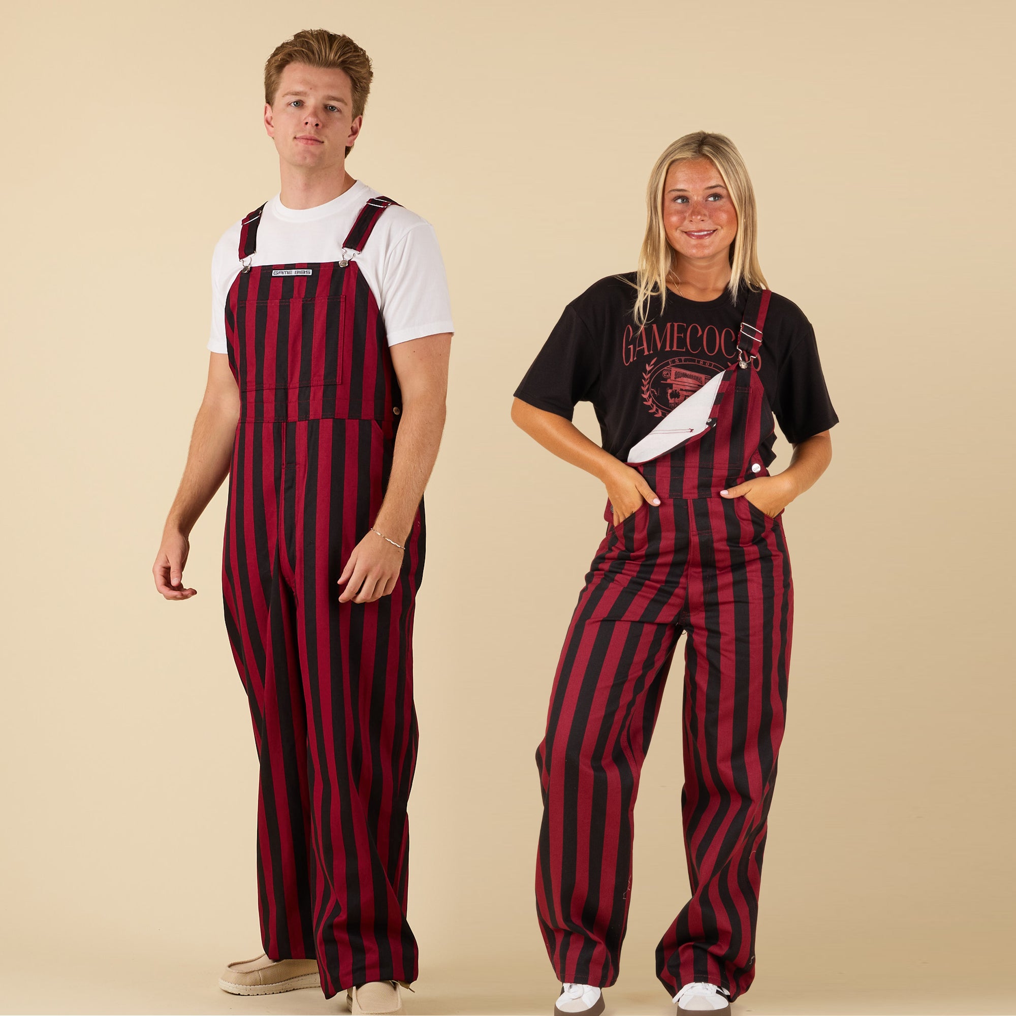 Two people wearing red and black striped overalls on a beige background