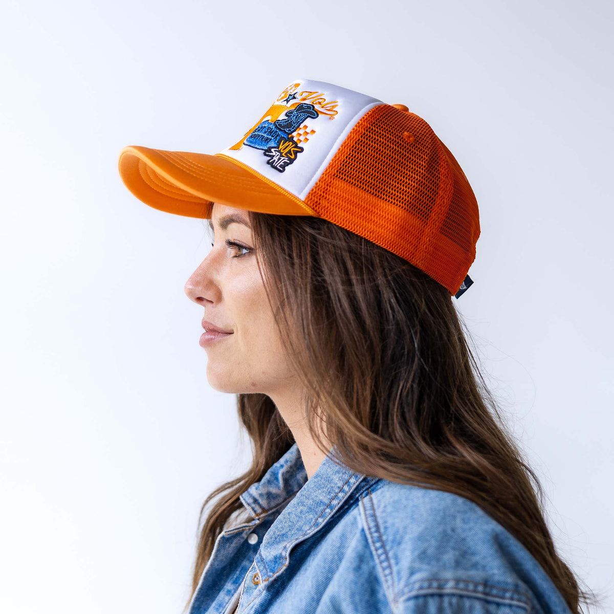 Woman wearing orange and white University of Tennessee Volunteers trucker hat with embroidered patch featuring Power T and Smokey.