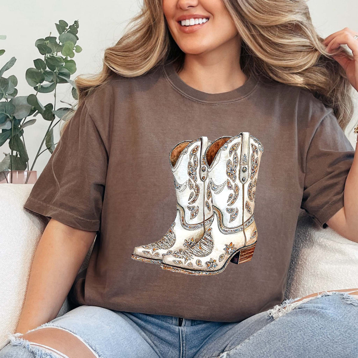 Espresso brown t-shirt with graphic of detailed white western cowboy boots adorned with sparkling floral and swirl embellishments, centered on the front.
