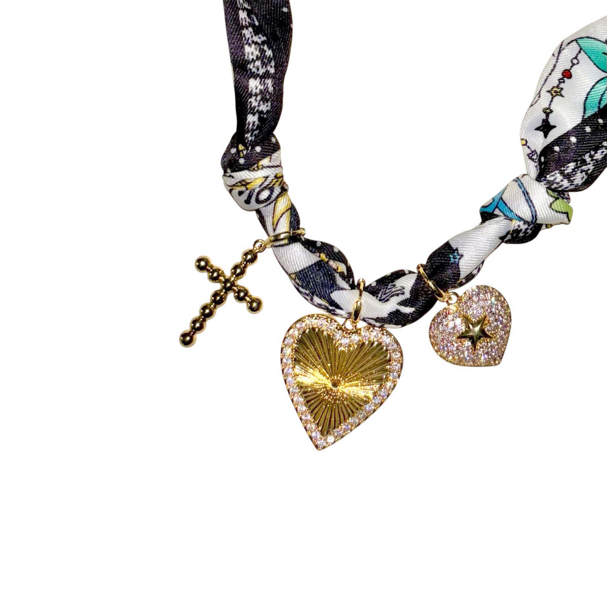 Multicolor knotted fabric necklace with gold-tone cross, rhinestone heart charm, and glitter heart charm with star accent.
