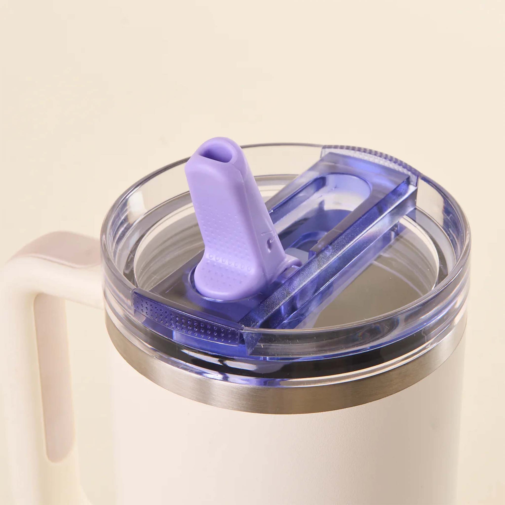 Close-up of periwinkle purple flip straw lid on a white tumbler with the silicone straw flipped open.
