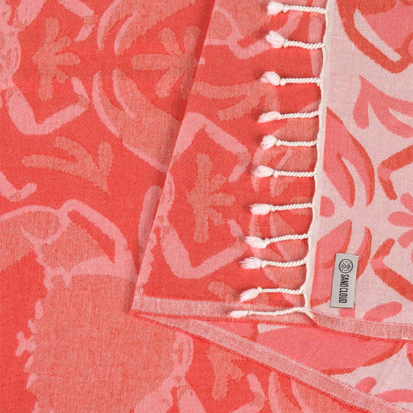 Coral and peach patterned fabric with a Sand Cloud label.