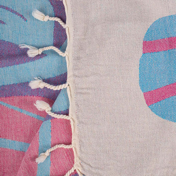 Close-up of a colorful fabric with geometric patterns and tassels.