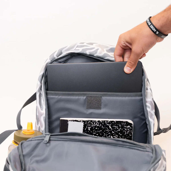 Person opening a backpack with a laptop and notebook inside, on a white background