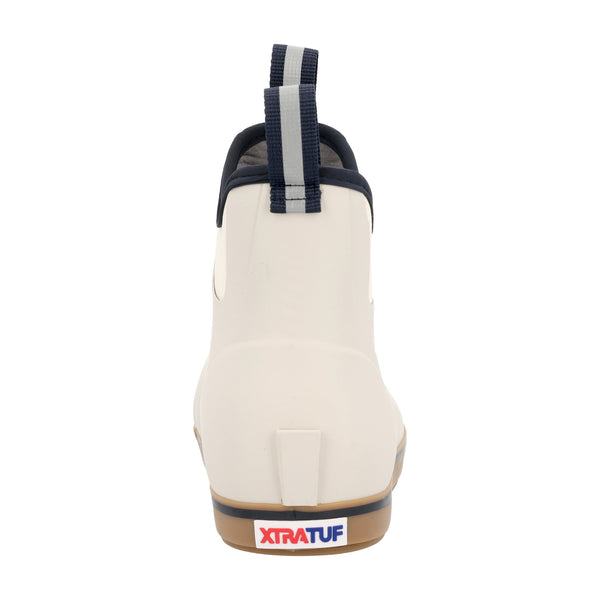 Back view showing dual pull-tabs in Navy for easy on and off, a raised ankle collar, and a beige  outsole with heel support.