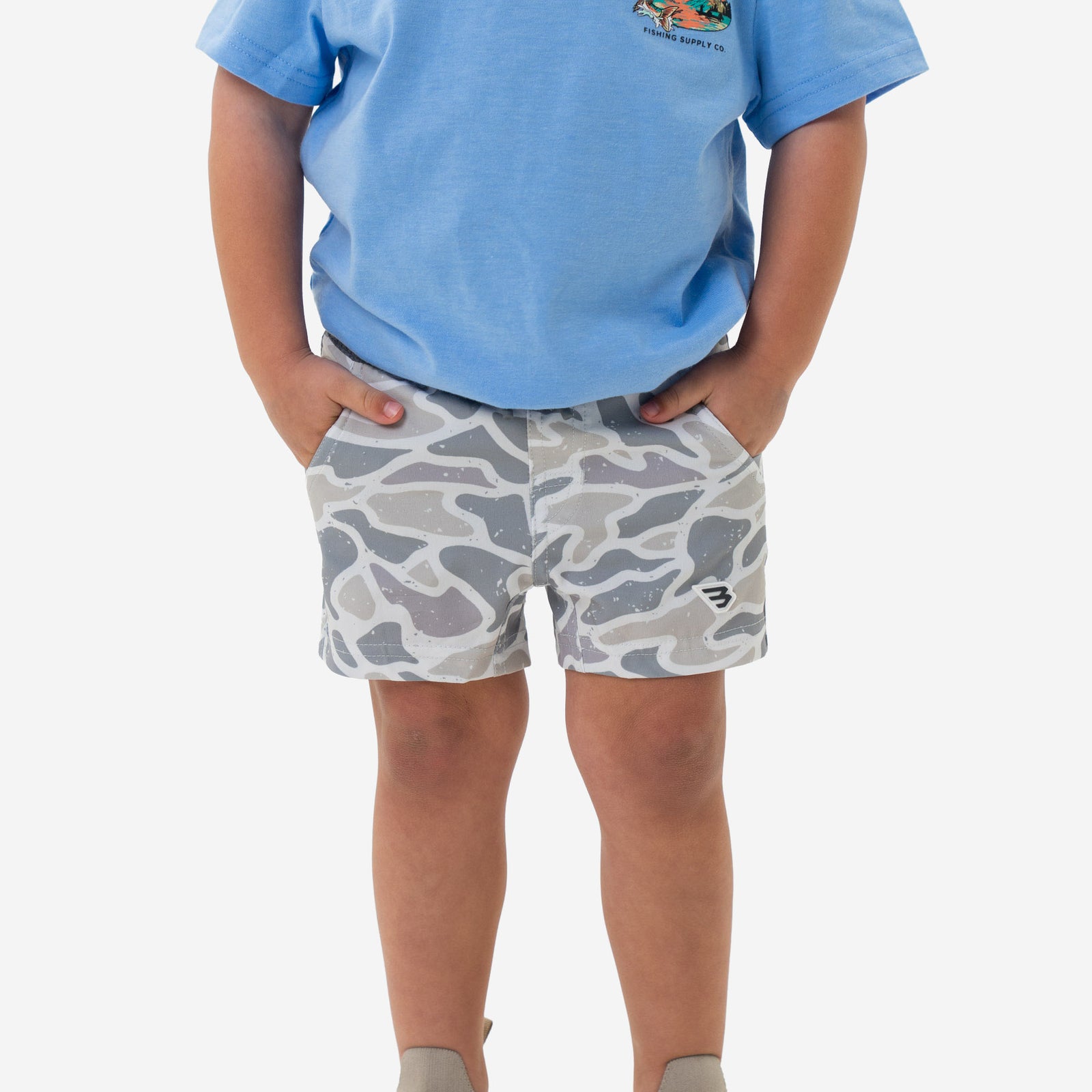 Child wearing a blue shirt and Burlebo Youth Athletic Shorts in White Camo in front of a white background.