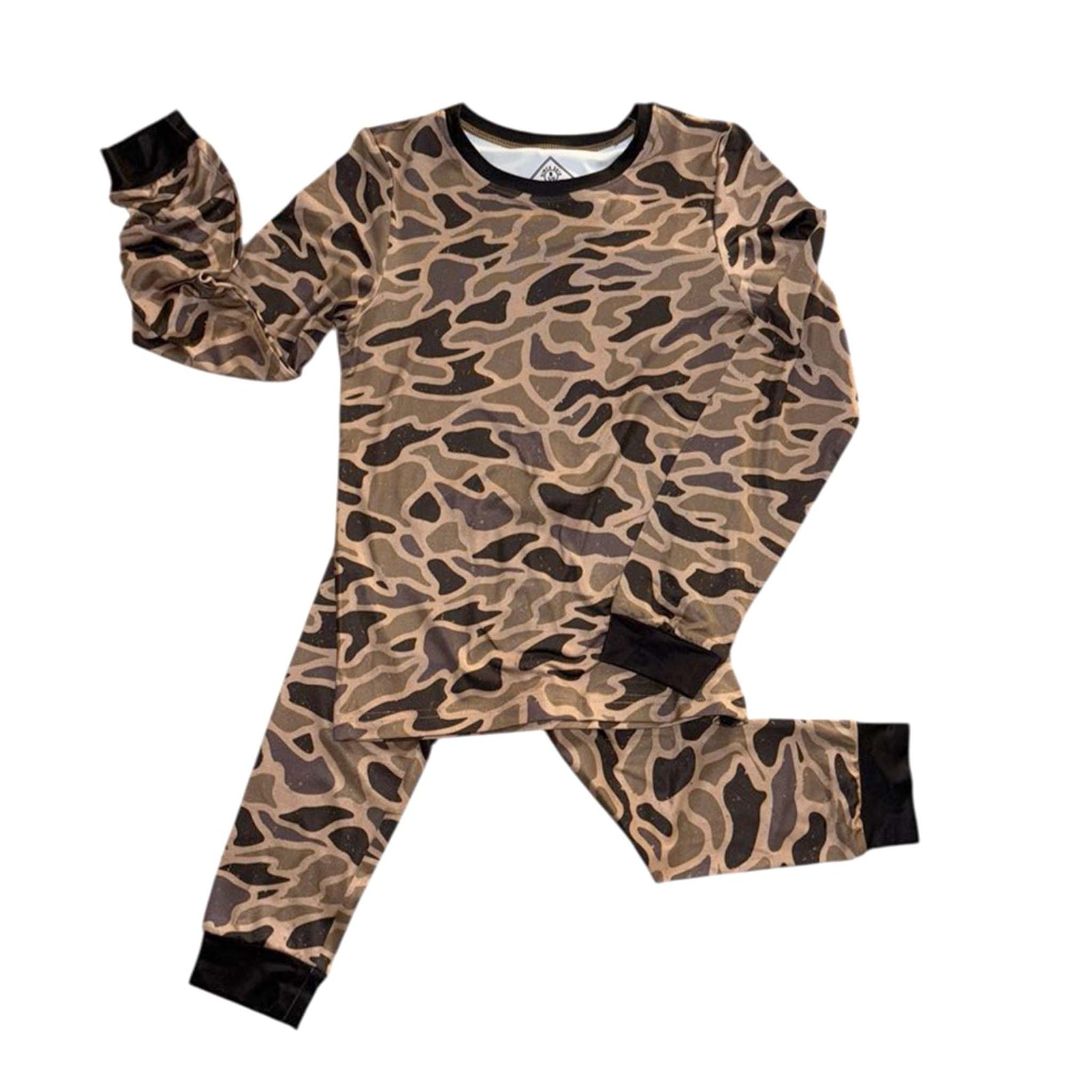 Youth pajama set in gauge camo print laid out flat, showing the long-sleeve top and matching pants with black cuffs.