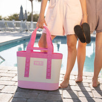 Woman standing by the pool with a YETI Camino.
