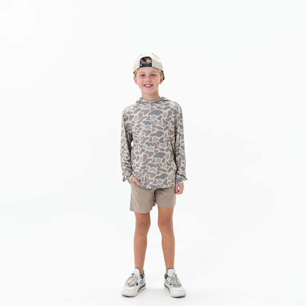 Full body view of Burlebo Youth Performance Hoodie shown on a young boy wearing the Classic Deer Camo pattern. 
