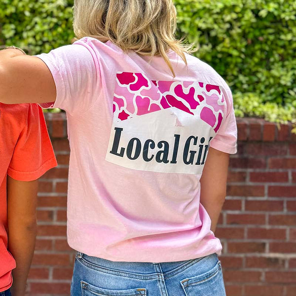 Local Girl Outfitters short sleeve t-shirt, color blossom pink, sizes S-XXL, 100% cotton. Woman wearing the local girl shirt in an outdoor setting displaying the back design.