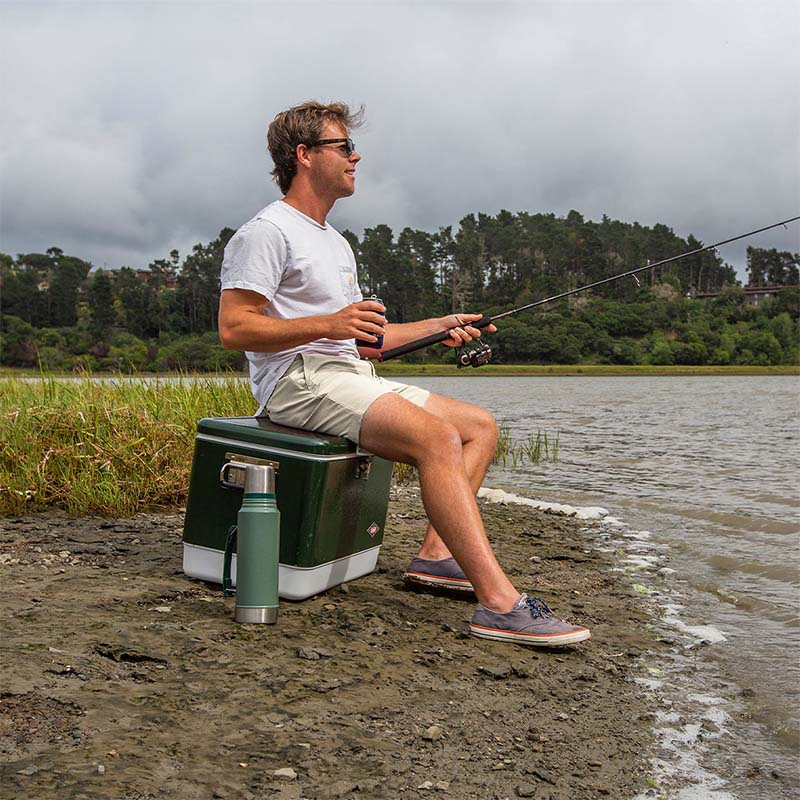 guy sitting on a cooler and fishing