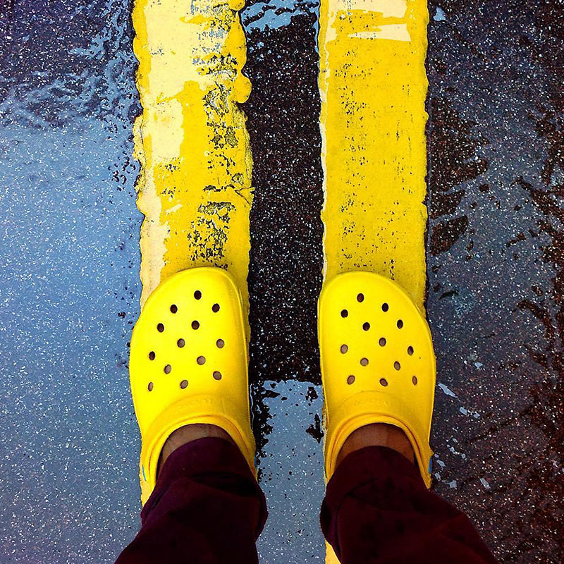 Adult Classic Clog in Yellow being worn on the street