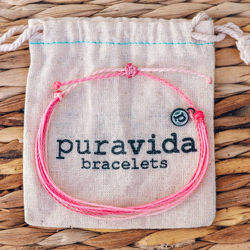 Pura Vida Pink and White Bracelet on top of a jewelry bag